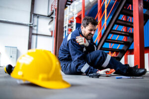 Image of fallen factory worker with an injured shoulder.