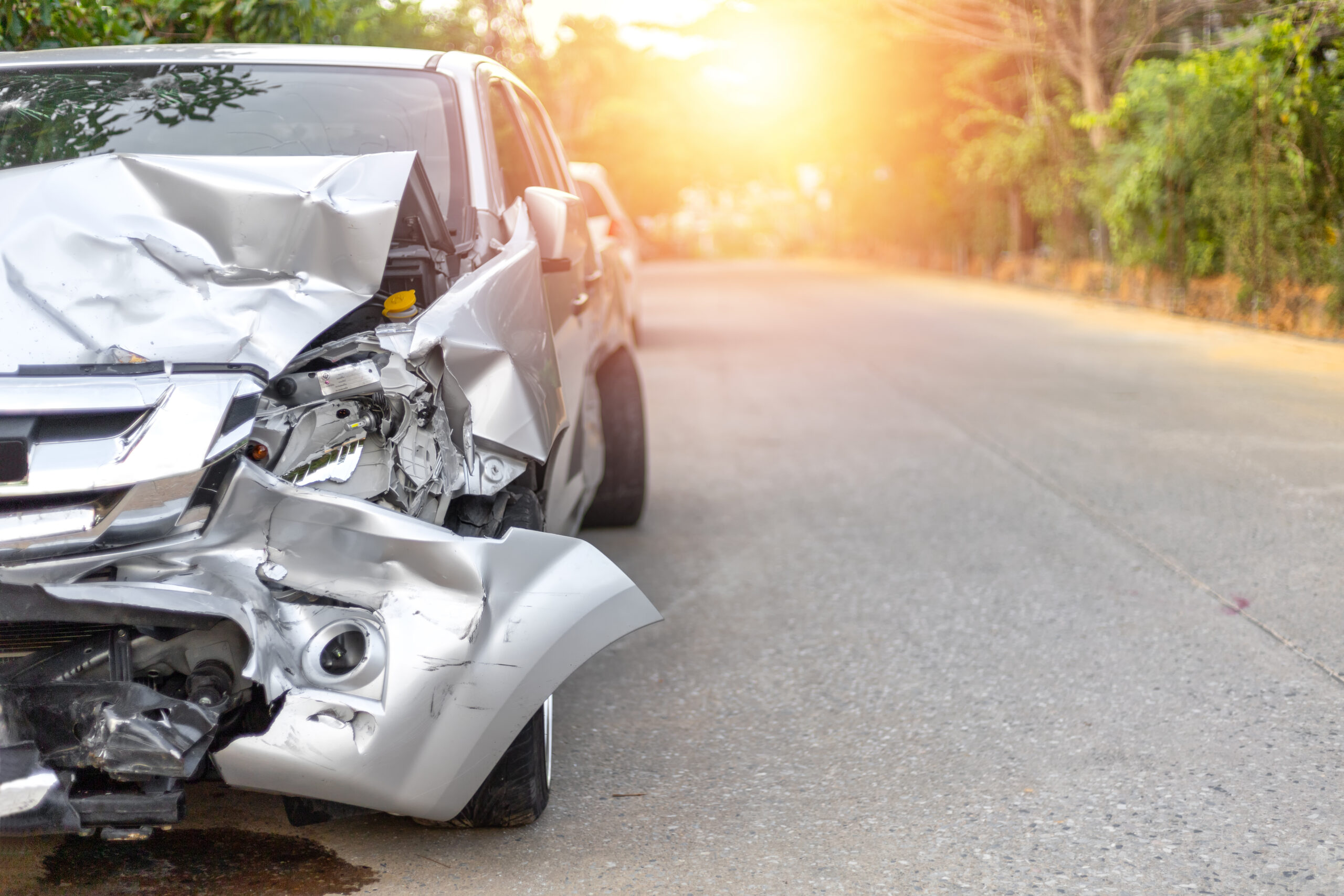Closeup of a car on the side of the road damaged in an auto accident.