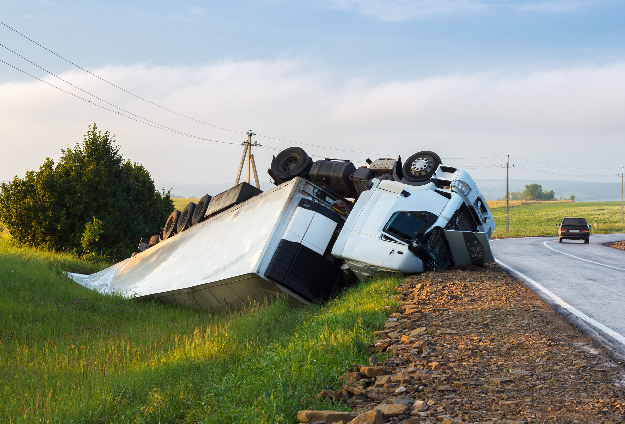 Semi-truck overturned on the left side of a highway